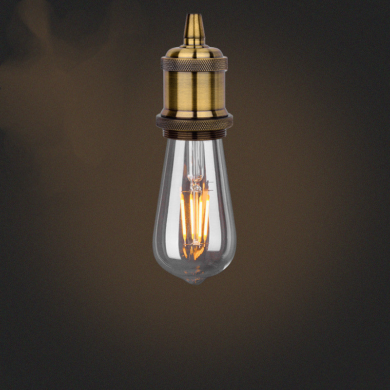 Vintage-style light bulb with brass fitting on a dark background