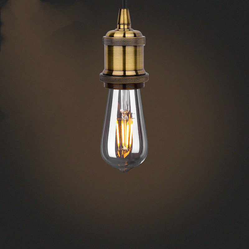 Vintage-style light bulb with brass fitting on a dark background