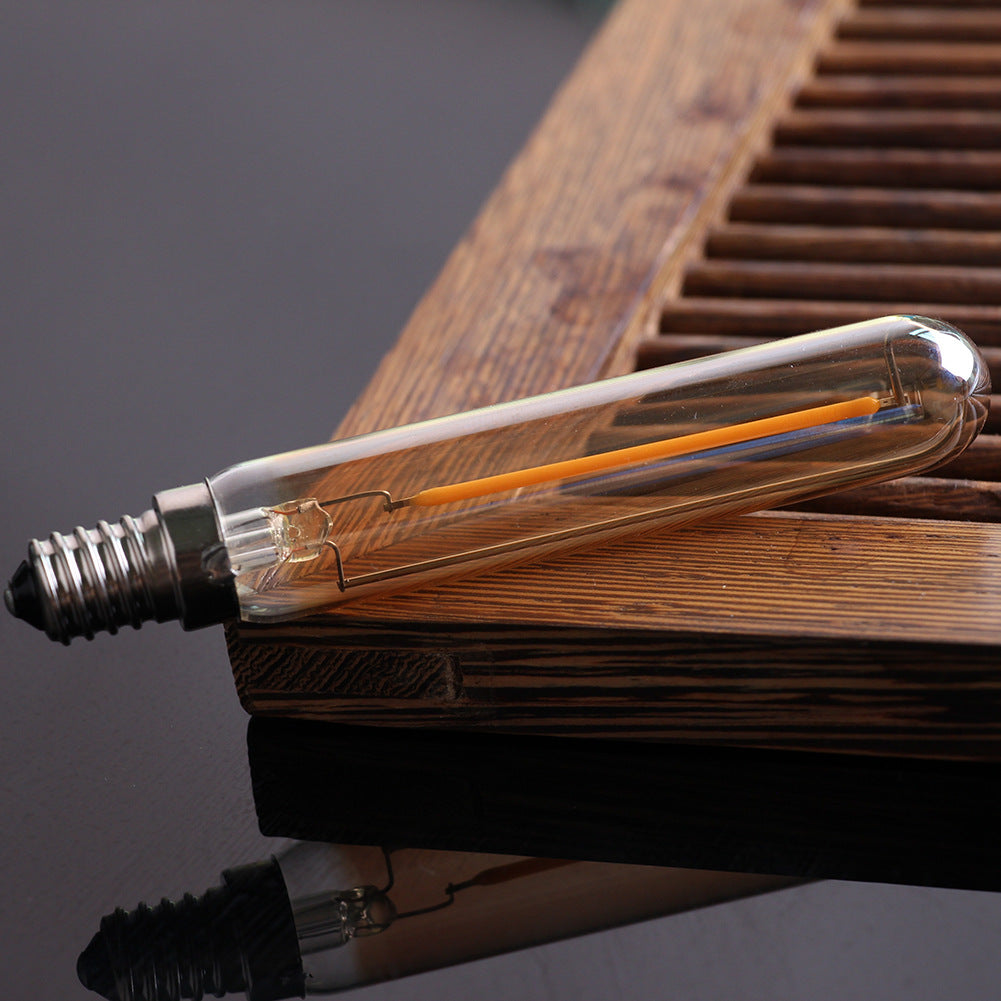 Clear LED light bulb on a wooden surface with a dark background