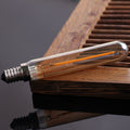 Clear LED light bulb on a wooden surface with a dark background