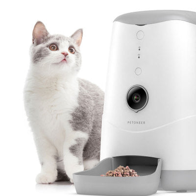 Cat next to a pet feeder on a white background