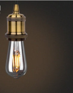 Vintage-style light bulb with brass fitting on a dark background