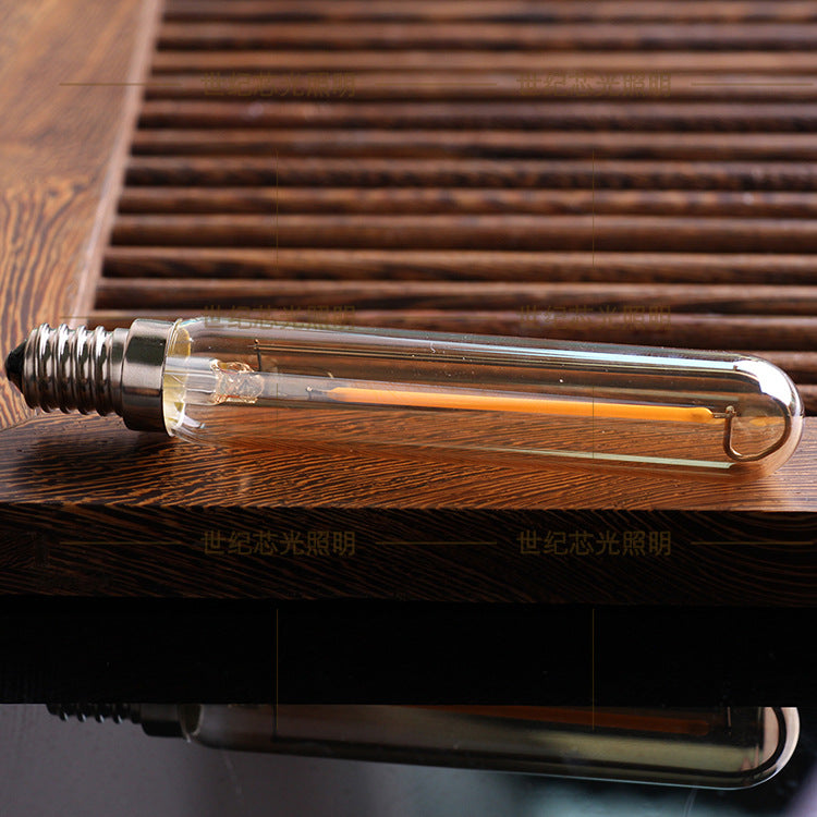 Vintage-style light bulb on a wooden surface