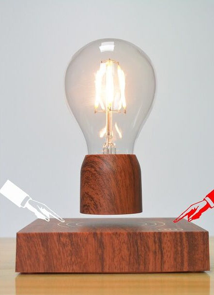 Wooden base with a levitating light bulb on a gray background