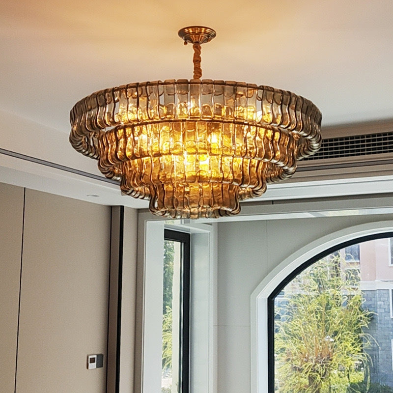 Gold chandelier hanging in a room with large windows
