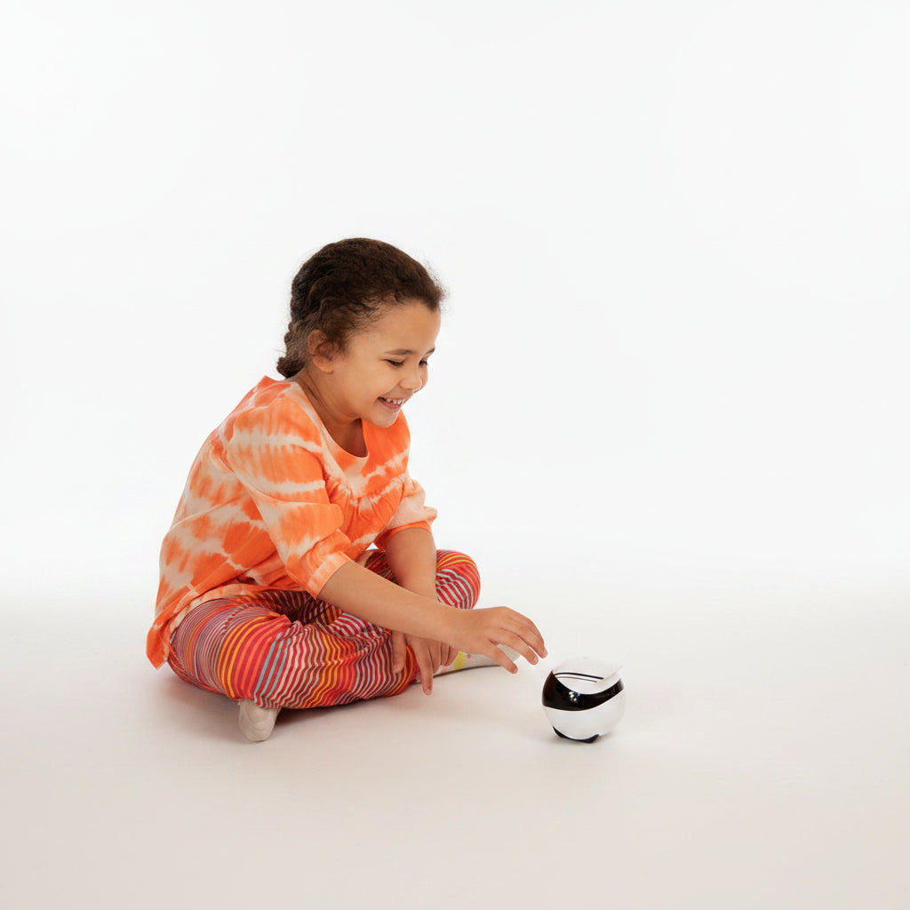 Child interacting with a small robot on a wooden floor in a home setting