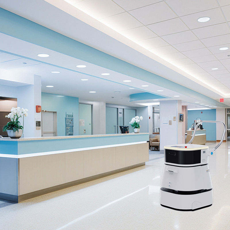Robotic device in a hospital setting with a reception desk and hallway in the background.