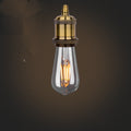 Vintage-style light bulb with brass fitting on a dark background