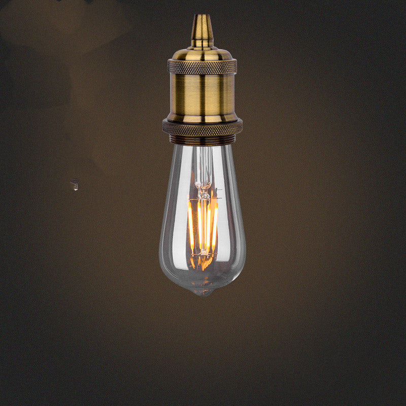 Vintage-style light bulb with brass fitting on a dark background