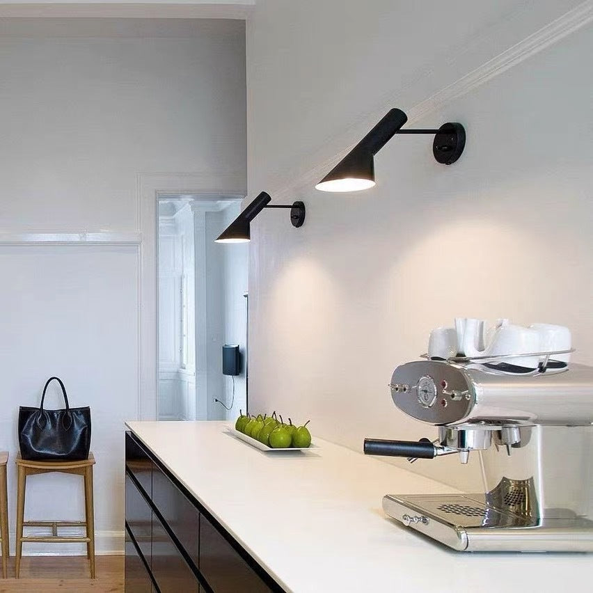 Modern kitchen with espresso machine, fruit plate, and wall lights.