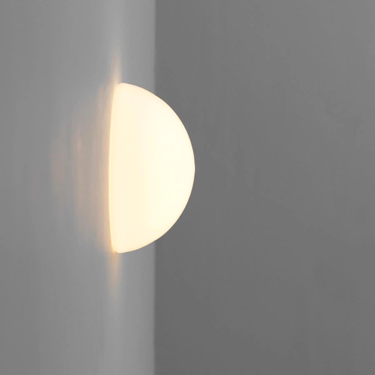Modern wall-mounted light fixture on a gray background
