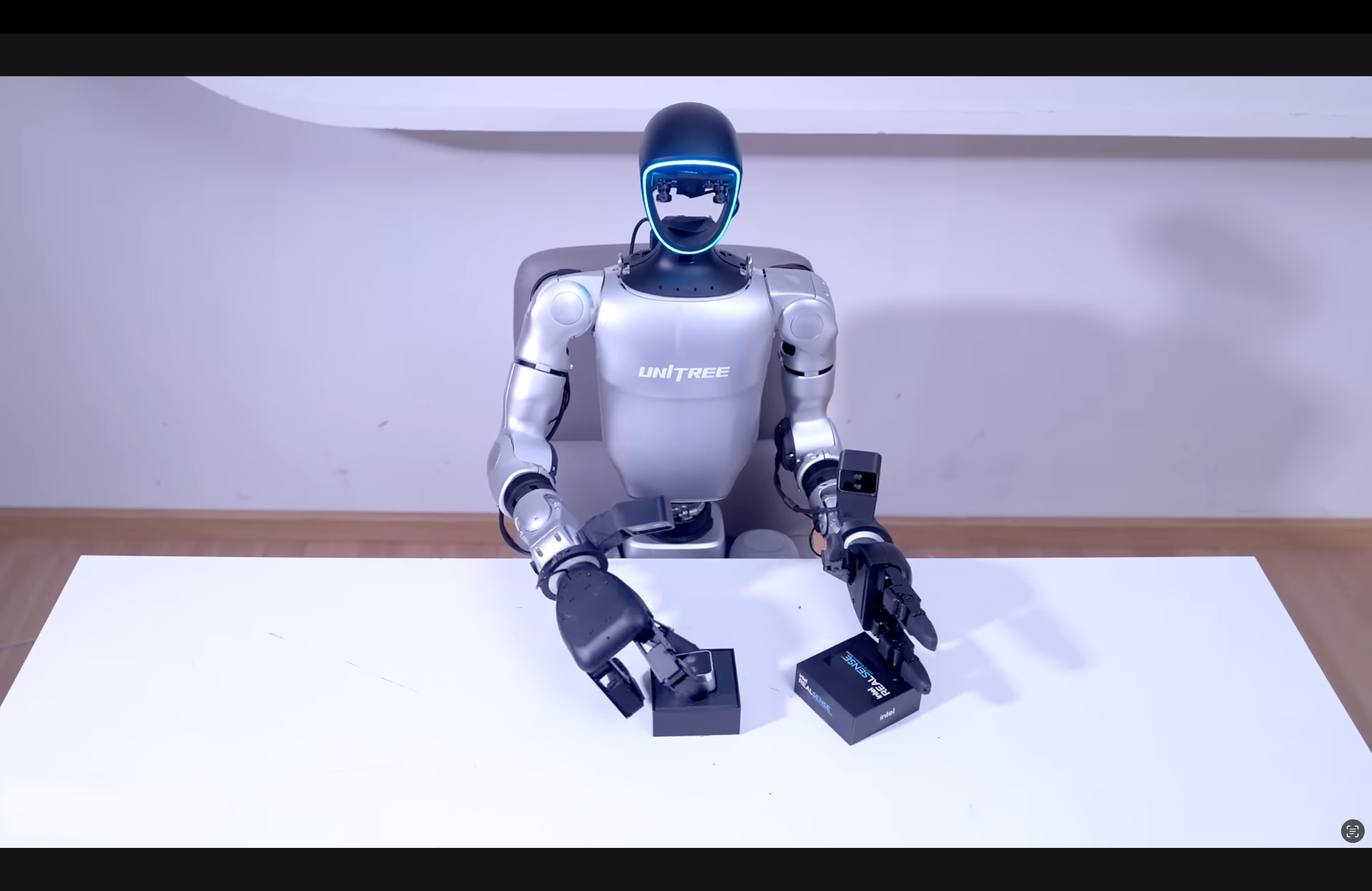 Robot sitting on a white surface with a neutral background